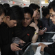 North Koreans inspect a tablet for sale at a market in Pyongyang. (Image: AP)
